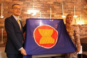 武光明大使将东盟会旗和柏林东盟委员会主席一职移交给文莱大使。（图：越通社）