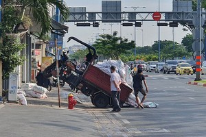 运送建材的三轮车在第五郡武文杰街人行道上前轮飃起。