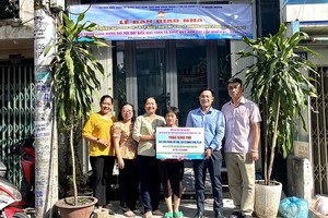 第六郡坊领导和本报领导等向罗丽娇移交温情屋。