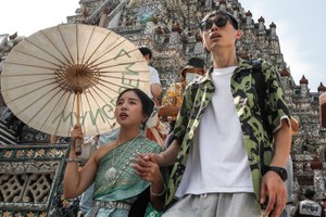 从今年3月起，泰中两国将施行永久互免对方公民签证。图为2023年12月29日来访曼谷黎明寺的中国游客。（图：EPA）