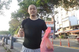 日本人马萨在第一郡饶禄涌岸边捡拾垃圾。