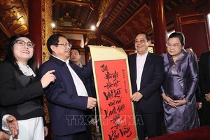 政府总理范明政（左二）在玉山寺里向老挝总理宋赛‧西潘敦赠送书法作品一幅。（图：越通社）