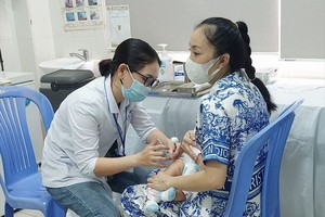 医护人员正给一名婴孩接种疫苗。（图：市卫生厅）