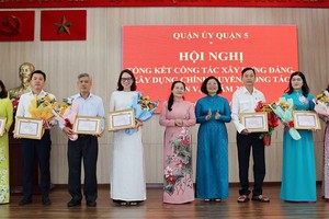 市委副书记、人民议会主席阮氏丽和第五郡郡委书记黄玉女芳红向出色集体颁发奖状。