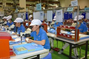 本市高科技园区一家外资企业的工人在操作生产。