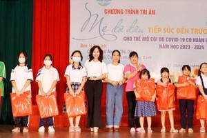 学生们在守德市妇联会举办的“义母”感恩活动中领取礼物。