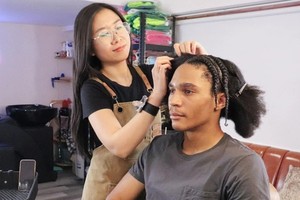 阮卿可薇（左）给杰梅因‧哈迪森编发造型。