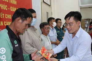 华文《西贡解放日报》编委文忠孝向贫困者赠送礼物。