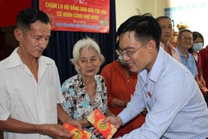 华文《西贡解放日报》编委文忠孝向贫困者赠送礼物。