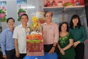 市委民运处副主任陈春田（左二）和陪同团向朱杞文赠送贺年礼物。