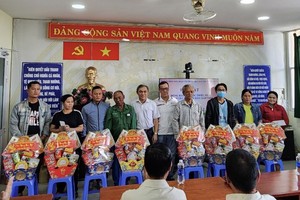 市民族处主任黄文鸿玉和穗城会馆理事会委员徐国樑向少数民族同胞赠送礼物。