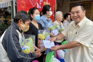 双成隆安公司董事长丁文森向穷人赠送新年礼物。