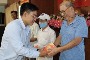 本报编委文忠孝向贫困华人赠送礼物。