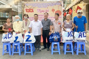 第六郡第三坊人委会副主席连志光和华企丁文森向穷人赠送礼物。