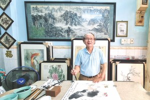 李炳全画家正在画水墨画。