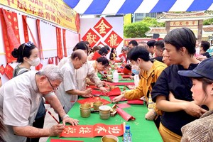 各书法家为民族挥毫挥春乐而不疲。