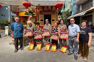 富山五行庙慈善组组长邹国荣（右二）和慈善组成员向贫困者赠送礼物。