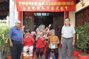 二府会馆副理事长谢忠成（右）、彭志光（左）向诸位高龄乡亲赠送春节敬老礼物。