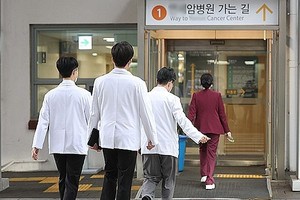 2月19日，在首尔一家大学医院，医生走在医院门口。（图：韩联社）