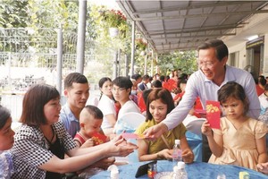 市人委会主席潘文迈在芽皮县协福工业区工人住宿区赠送压岁钱给没回家过年的工人。