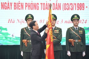 国家主席武文赏向边防部队的决战决胜旗帜别上二等战功勋章。（图：越通社）