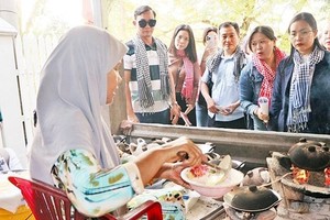 遊客观看师傅製作哈孤发糕。