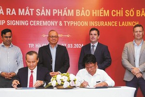 广南省协顺农业合作社代表（右）与保明公司签订首份投保合同。