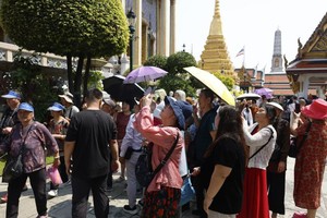 游客参观曼谷大王宫的玉佛寺。（图：EPA）