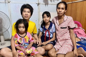 陈富创与妻女在租住的房间里。