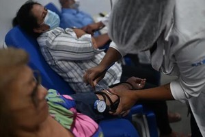 一名医护人员正在为患者测量血压。（图：AFP）