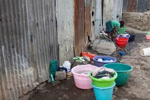 肯尼亚水资源紧张。3月21日，肯尼亚内罗毕玛塔雷贫民窟内的一名妇女正在洗衣服。（图：AFP）