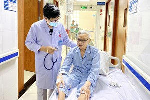 吴世煌医生为一位住院就医的大爷诊断疾病。