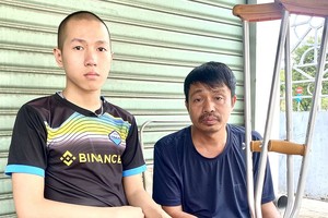 被锯掉右脚的阮进英和父亲阮文陵。