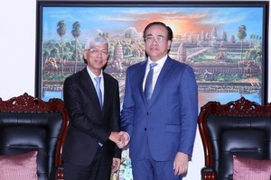 市人委会副主席武文欢（左）与柬埔寨驻本市总领事陈索里坎（Chan Sorykan）握手合影。（图：越通社）