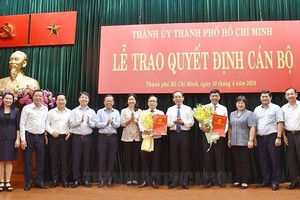 市委书记阮文年（右五）同与会代表向两位接受新任务的同志祝贺并合影留念。（图：市党部新闻网）