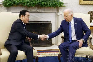 日本首相岸田文雄（左）与美国总统拜登在会谈上握手。（图：共同社）