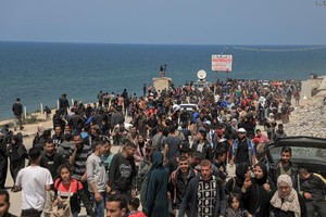 这是4月14日在加沙地带中部拍摄的向北返家的人群。（图：新华社）