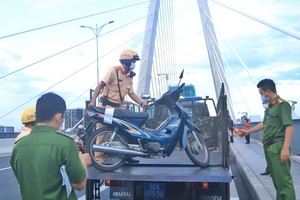 交警拘留停在桥上的摩托车。