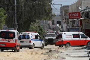 4月20日，在约旦河西岸城市图勒凯尔姆，以色列军车阻止救护车进入冲突现场。（图：新华社）