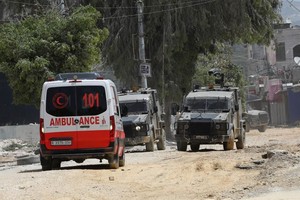 20日，在约旦河西岸城市图勒凯尔姆，以色列军车阻止救护车进入冲突现场。（图：新华社）