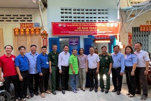 郡、坊领导和庆云南院住持周华邦向贫困户移交修缮“温情屋”工程。