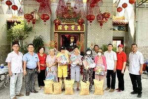 曾文良主席（右二）和各位理监事向穷苦人家派发礼物。