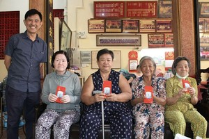 海南会馆第四十三届理事长林明辉（左一）向孤寡贫困乡亲送出关怀。