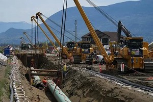 图为 2023年5月3日，不列颠哥伦比亚省阿伯茨福德，工人们在跨山管道扩建工程中铺设管道。（图：加新社）