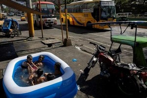 4月29日，在菲律宾马尼拉，儿童在充气泳池玩水消暑。（图：路透社）