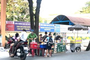 学生在学校门口的肩挑小贩购买食品。