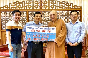 释了明法师向本报主编阮玉英转交“赠报计划”赞助2000万元。