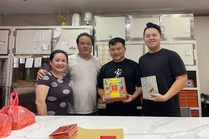 赵明合饼家第四代传人赵家安（右一）指导员工制作朥饼。