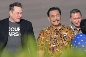 5月19日，马斯克（左）乘私人飞机抵达印度尼西亚峇厘岛，印尼海洋与投资统筹部长卢胡特（黄衬衫）到场迎接。（图：AFP）