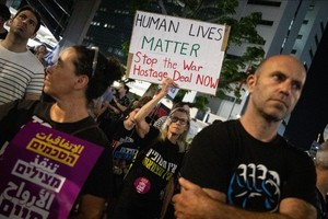 18日，以色列民众要求政府立即在加沙地带止战停火与哈马斯达成协议，让被扣押人员获释。（图：新华社）